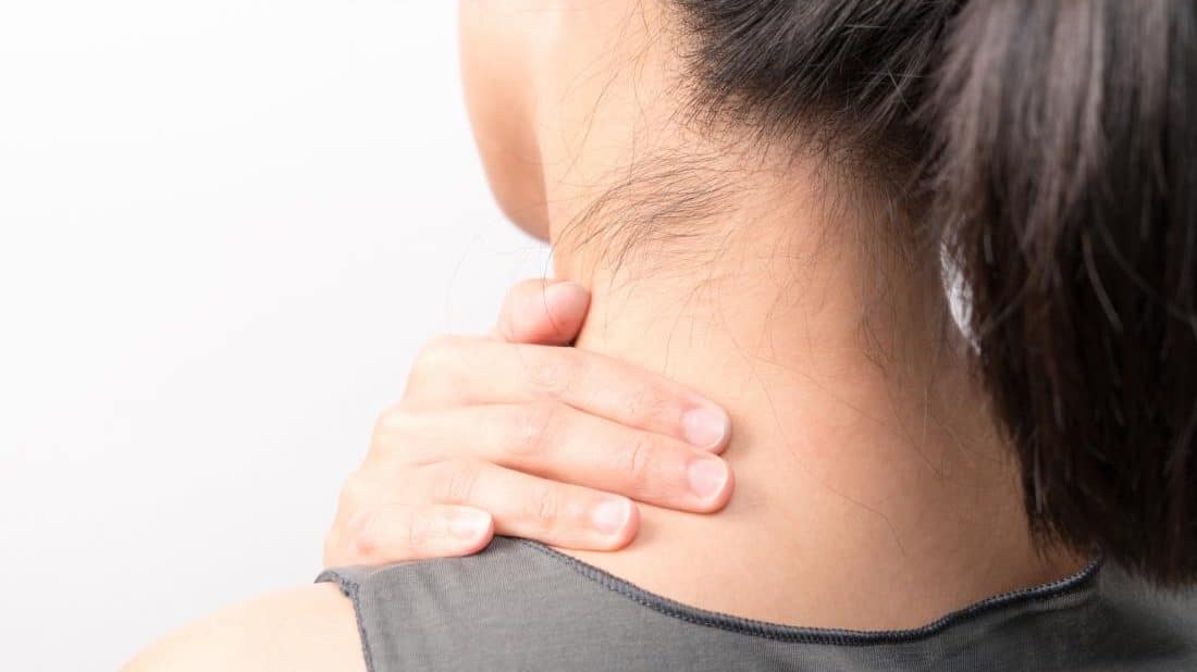 cropped woman holding her neck due to pimple on neck
